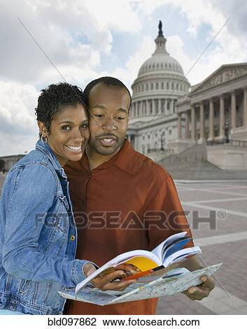 Stock Image - Black couple sightseeing with map. Fotosearch