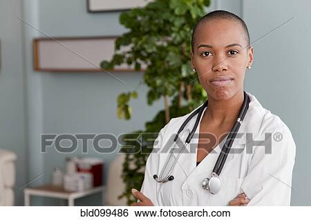 Stock Photograph - Black doctor standing in doctor's office. Fotosearch