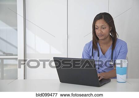 Stock Photo - Black doctor using laptop. Fotosearch