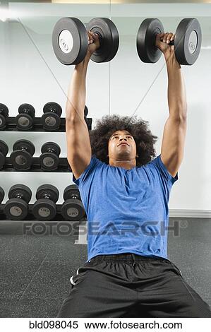Black man lifting dumbbells in gym View Large Photo Image Stock Photography - Black man lifting dumbbells in gym. Fotosearch