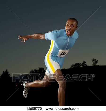 Stock Image - Black runner crossing finish line in race. Fotosearch