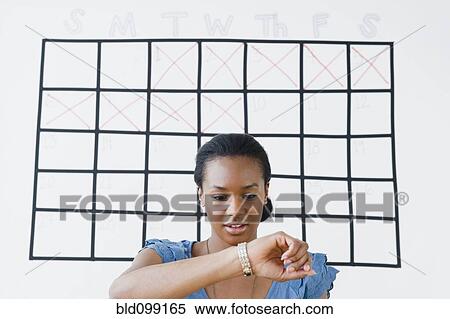 Stock Photography - Black woman checking her wristwatch. Fotosearch