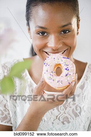 Black woman eating donut View Large Photo Image Stock Image - Black woman eating donut. Fotosearch