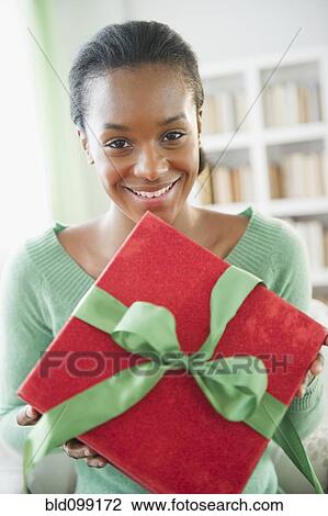 Black woman holding Christmas gift View Large Photo Image Stock Image - Black woman holding Christmas gift. Fotosearch