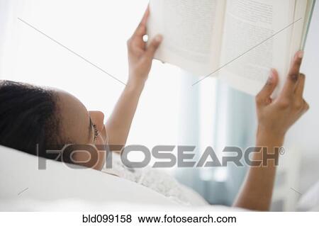 Stock Photo - Black woman reading a book. Fotosearch