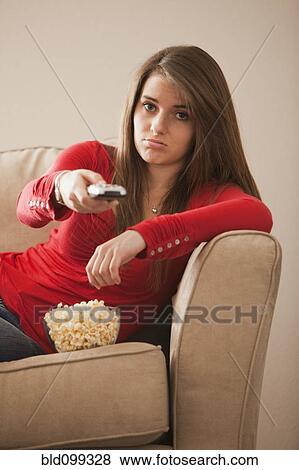Stock Photo - Bored Caucasian woman watching television. Fotosearch