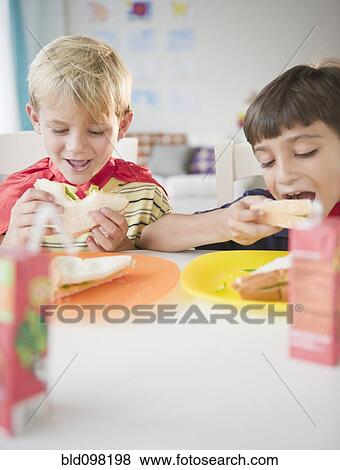 Stock Photo - Boys eating lunch together. Fotosearch