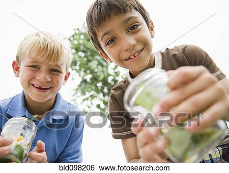 Boys holding jars catching bugs View Large Photo Image Stock Photograph - Boys holding jars catching bugs. Fotosearch