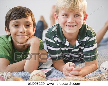 Stock Photo - Boys laying on bed together. Fotosearch
