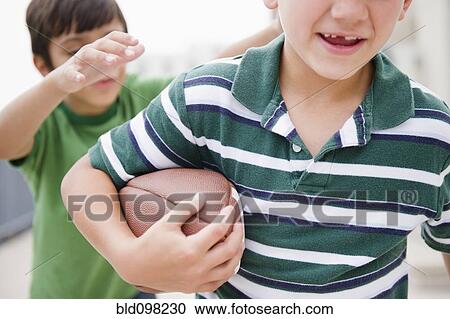 Stock Image - Boys playing football. Fotosearch