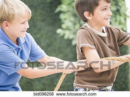Stock Photo - Boys pulling rope together. Fotosearch