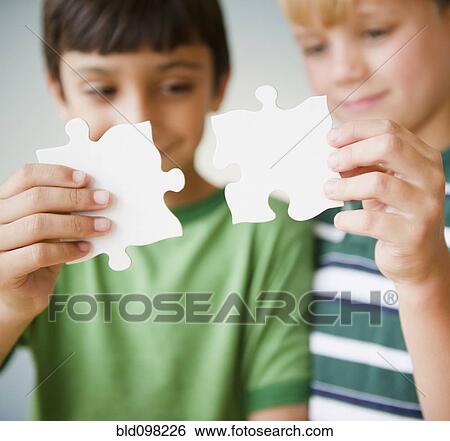 Stock Photograph - Boys putting jigsaw puzzle together. Fotosearch