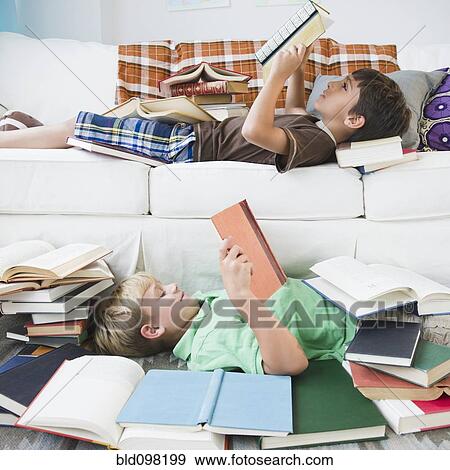 Boys reading books in living room View Large Photo Image Stock Photo - Boys reading books in living room. Fotosearch