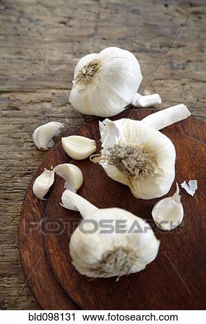 Stock Image - Bulbs of garlic on cutting board. Fotosearch