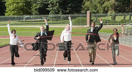 Stock Photo - Business people running across track finish line. Fotosearch