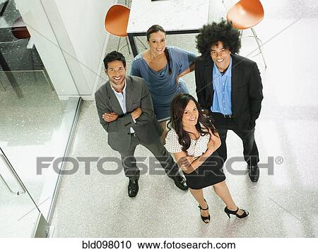 Stock Image - Business people standing together in office. Fotosearch