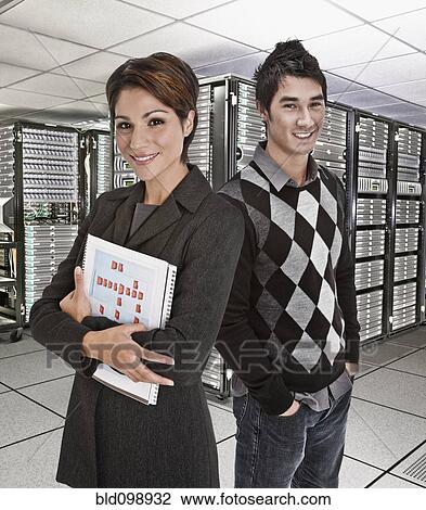 Stock Image - Business people standing together in server room. Fotosearch