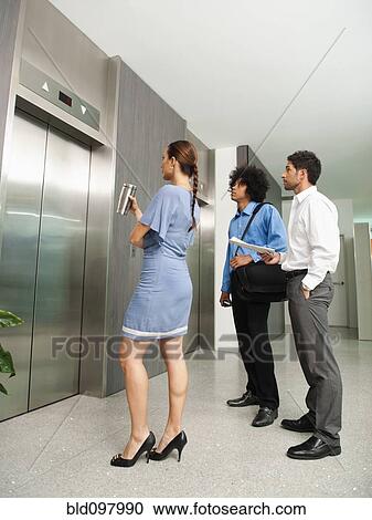 Stock Image - Business people waiting for elevator. Fotosearch