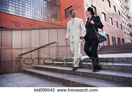 Stock Image - Business people walking down steps. Fotosearch