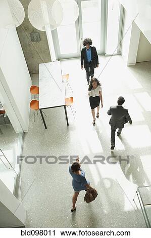 Business people walking in office View Large Photo Image Stock Image - Business people walking in office. Fotosearch