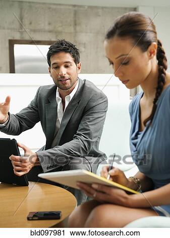 Stock Image - Business people working together in lobby. Fotosearch