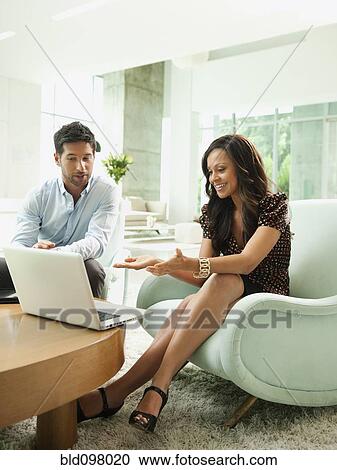Stock Image - Business people working together in lobby. Fotosearch