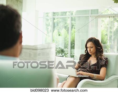 Stock Image - Business people working together in lobby. Fotosearch