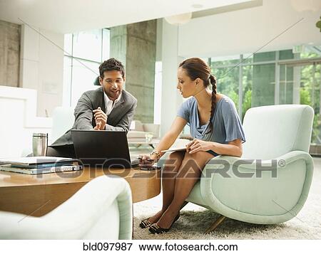 Stock Photo - Business people working together in lobby, . Fotosearch