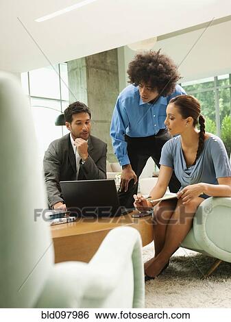 Stock Photograph - Business people working together in lobby. Fotosearch