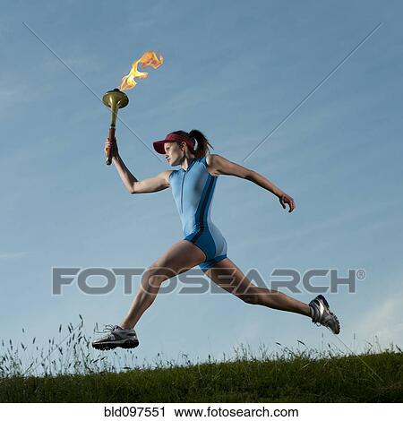 Caucasian athlete running with Olympic torch View Large Photo Image Stock Image - Caucasian athlete running with Olympic torch. Fotosearch