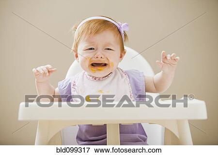 Stock Photo - Caucasian baby girl crying in high chair. Fotosearch