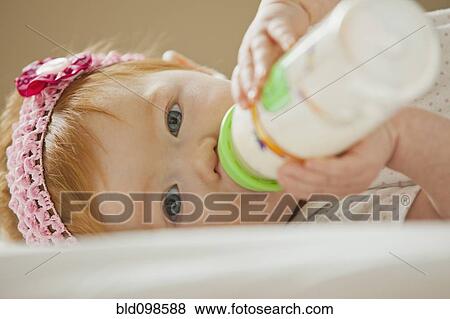 Caucasian baby girl drinking bottle View Large Photo Image Stock Photo - Caucasian baby girl drinking bottle. Fotosearch
