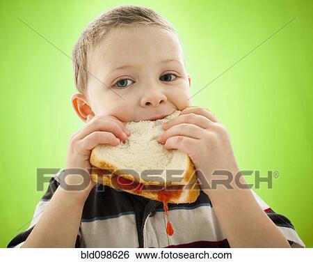 Stock Photograph - Caucasian boy eating peanut butter and jelly sandwich. Fotosearch