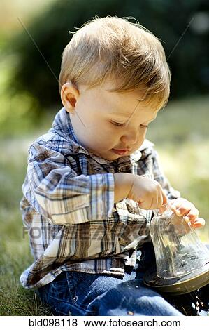 Stock Photo - Caucasian boy holding jar. Fotosearch