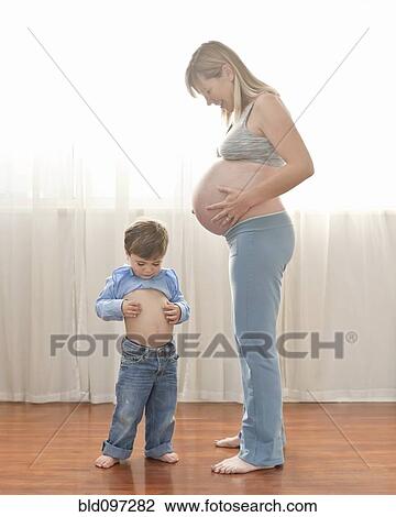 Stock Image - Caucasian boy imitating pregnant mother. Fotosearch