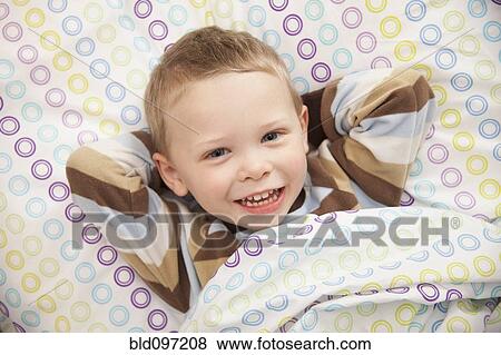 Stock Photo - Caucasian boy laying in bed. Fotosearch