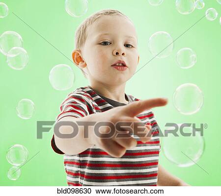 Stock Image - Caucasian boy popping bubbles. Fotosearch