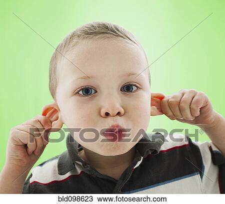 Stock Image - Caucasian boy pulling his ears. Fotosearch