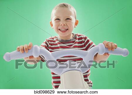 Caucasian boy riding plastic bicycle View Large Photo Image Stock Photo - Caucasian boy riding plastic bicycle. Fotosearch