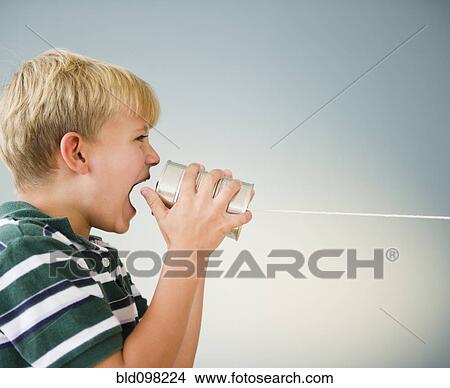 Caucasian boy shouting into tin can telephone View Large Photo Image Picture - Caucasian boy shouting into tin can telephone. Fotosearch