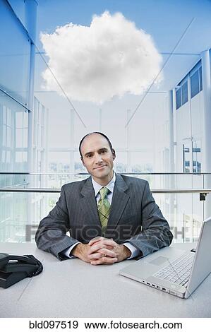 Caucasian businessman sitting at desk with cloud over his head View Large Photo Image Stock Photo - Caucasian businessman sitting at desk with cloud over his head. Fotosearch