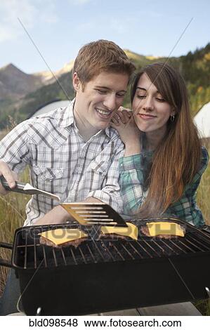 Caucasian couple cooking hamburgers on grill View Large Photo Image Stock Photo - Caucasian couple cooking hamburgers on grill. Fotosearch