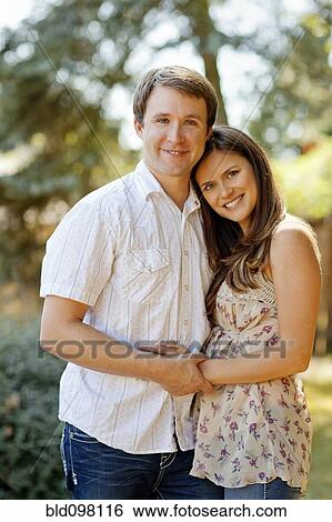 Stock Photograph - Caucasian couple hugging outdoors. Fotosearch
