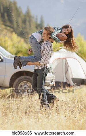 Caucasian couple playing football at campsite View Large Photo Image Stock Photograph - Caucasian couple playing football at campsite. Fotosearch