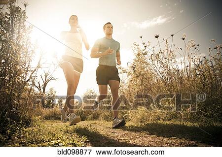 Stock Photo - Caucasian couple running together on path. Fotosearch