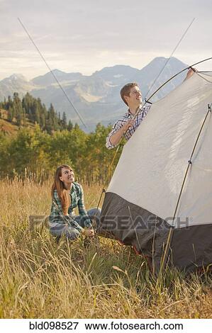 Stock Photo - Caucasian couple setting up tent. Fotosearch