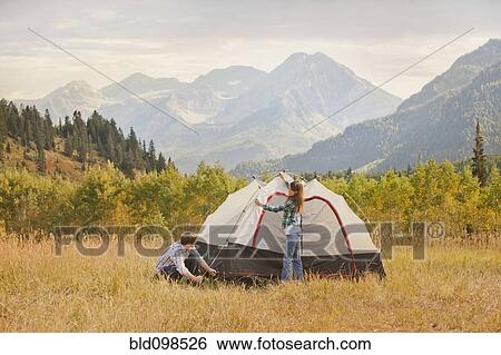 Stock Photograph - Caucasian couple setting up tent. Fotosearch