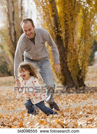 Caucasian father and daughter playing in autumn leaves View Large Photo Image Stock Photography - Caucasian father and daughter playing in autumn leaves. Fotosearch