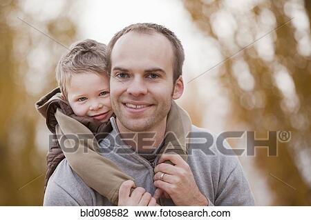Stock Image - Caucasian father and son hugging. Fotosearch