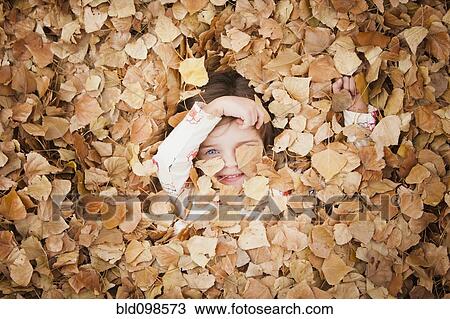 Caucasian girl laying in autumn leaves View Large Photo Image Stock Image - Caucasian girl laying in autumn leaves. Fotosearch